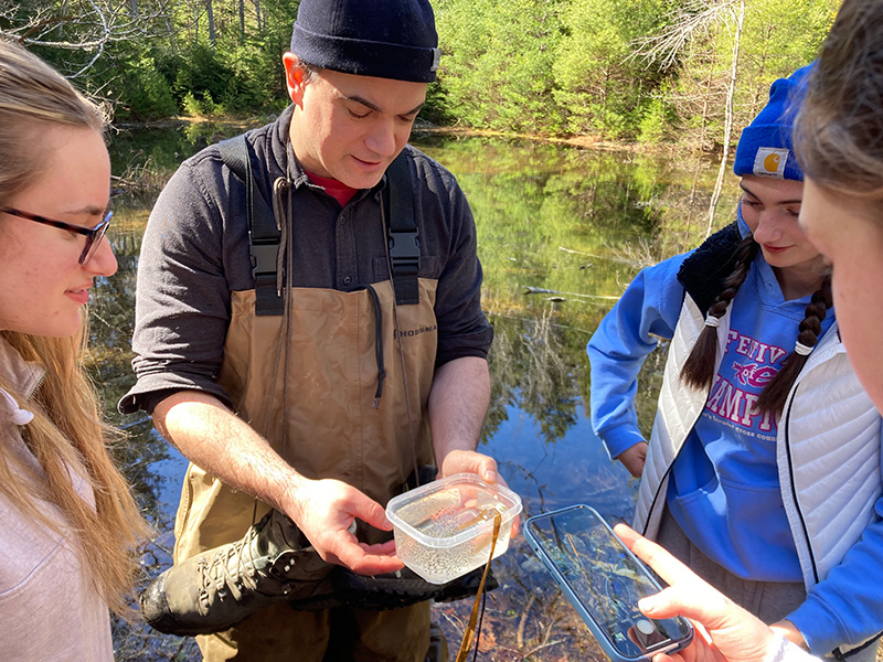 Senior Research Scientist John Burns with students from the AP Biology class at the regional high school into the field to find salamanders