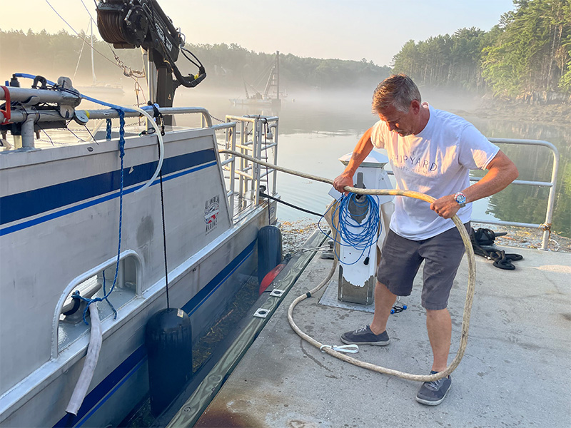 Capt. Dave Drapeau pulling an electrical cable on the Bigelow dock